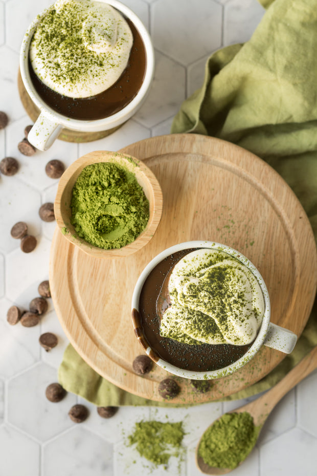 Matcha hot chocolate in mugs with matcha powder on a wooden board on a Marble Hexagon Tile Replica Photography Backdrop