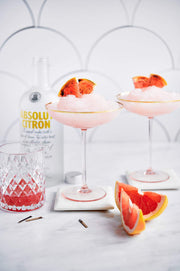 Two pink ice drinks in glasses with oranges and vodka with a Scalloped Tiles Replica Photography Backdrop