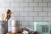 Super-Thin & Pliable Most Realistic Subway Tile Photography Backdrop 3ft x 2 ft Lightweight, Moisture & Stain-Resistant with a bread box, cups, and wooden spoons