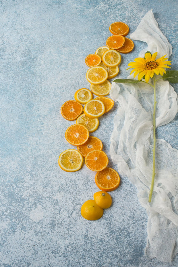 Super-Thin & Pliable Blue Stone Photography Backdrop 2 ft x 3ft, Lightweight, Moisture & Stain-Resistant with a sunflower and oranges