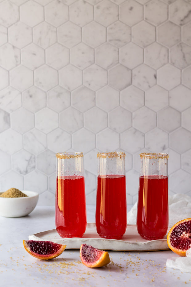 Red sparkling drinks with blood oranges and a Marble Hexagon Tile Replica Photography Backdrop