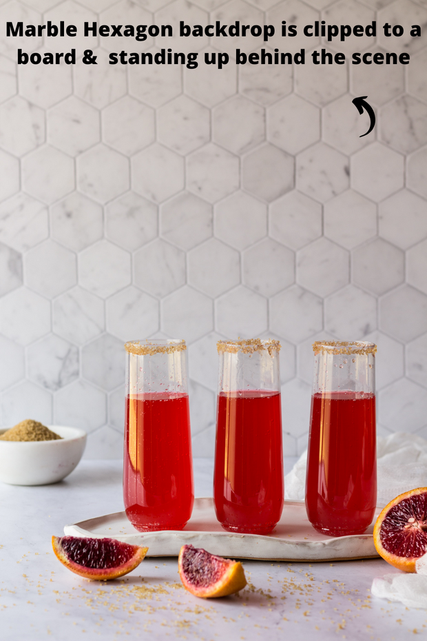 Glasses of red soda with blood oranges with a Super-Thin Marble Hexagon Tile Replica Photography Backdrop