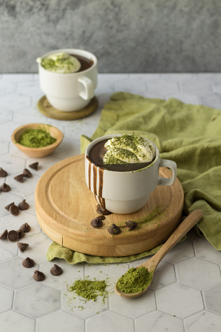 Two cups of matcha hot chocolate with chocolate chips on a Super-Thin Marble Hexagon Tile Replica Photography Backdrop