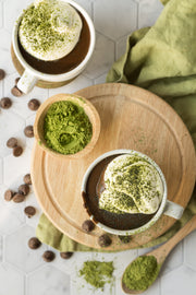 Matcha hot chocolate in mugs with matcha powder on a wooden board on a Marble Hexagon Tile Replica Photography Backdrop
