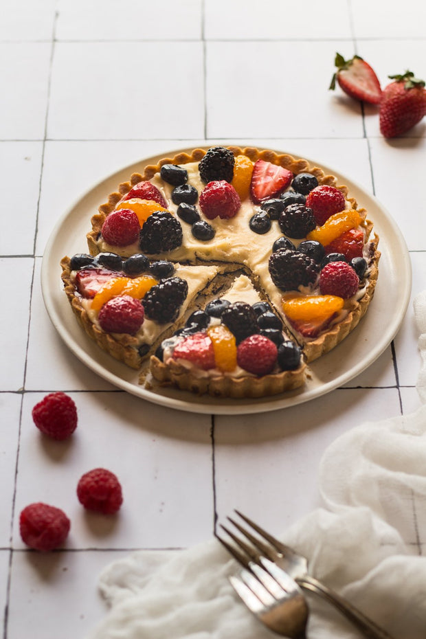 Mixed berry fruit tart on a plate with forks on a Moroccan Tile Replica Photography Backdrop 