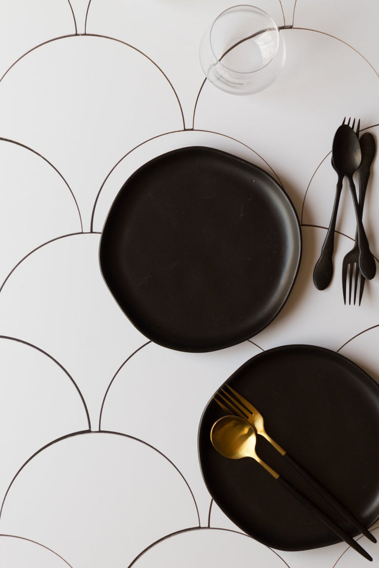 Black plates with spoons and forks on a Super-Thin & Pliable Scalloped Tiles Replica Photography Backdrop