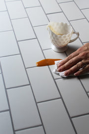 The Most Realistic Subway Tile Photography Backdrop 3ft x 2 ft | 3 mm thick with a spill being wiped clean