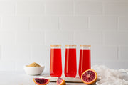 Subway Tile with White Grout Photography Backdrop  with three red sparkling drinks and blood oranges