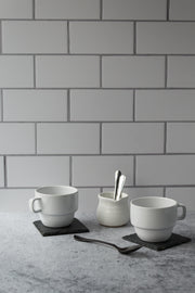 20-inch x 20-inch The Most Realistic Subway Tile Photography Backdrop 3 mm thick Physical Board, Lightweight, Moisture & Stain-Resistant with two coffee cups and a coffee creamer with spoons