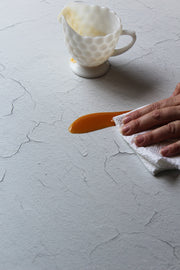 White Chipped Paint Photography Backdrop 2 ft x 3 ft | 3 mm thick with a spill being wiped clean