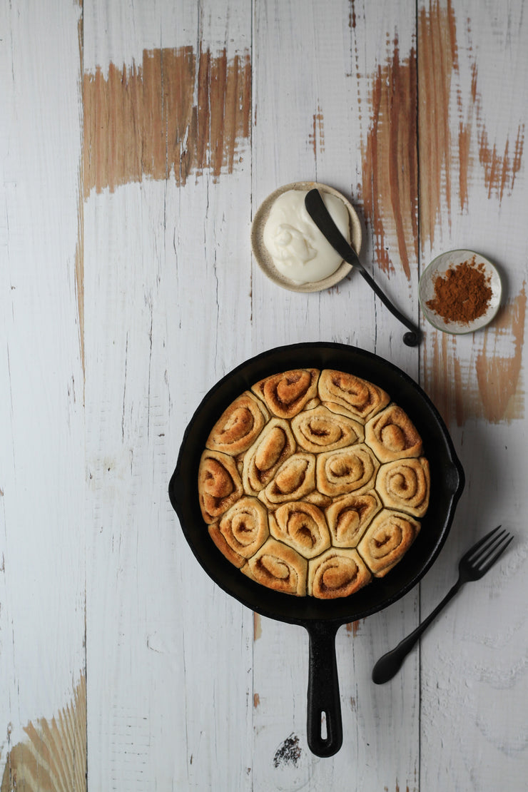 Whitewashed Reclaimed Wood Photography Backdrop 2 ft x 3 ft board | 3 mm thick with cinnamon rolls in a cast iron skillet